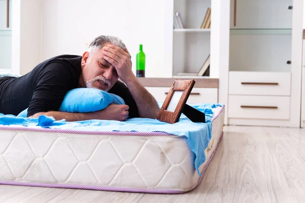 Alter Mann trinkt Wein im Schlafzimmer — Stockfoto