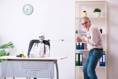 Yaşlı bacağı yaralı bir adam ölü doktoru ziyaret ediyor.