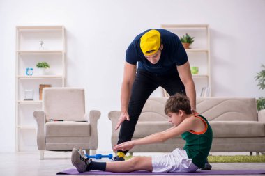 Baba ve oğul içeride spor yapıyor.