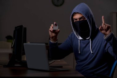 Erkek bilgisayar korsanı, güvenlik duvarını geç saatlerde hackliyor.