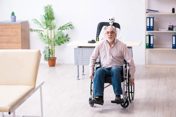 Velho na cadeira de rodas visitando médico morto — Fotografia de Stock