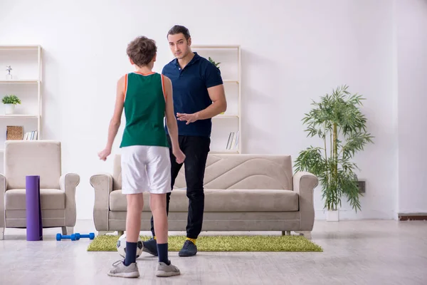 Pai e filho fazendo exercícios esportivos dentro de casa — Fotografia de Stock