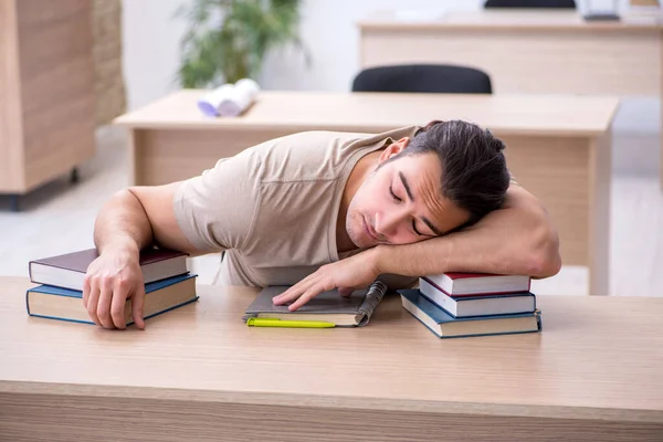 Jovem estudante se preparando para exames na biblioteca — Fotografia de Stock