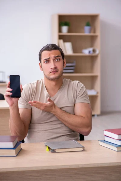 Młody student przygotowujący się do egzaminów w bibliotece — Zdjęcie stockowe