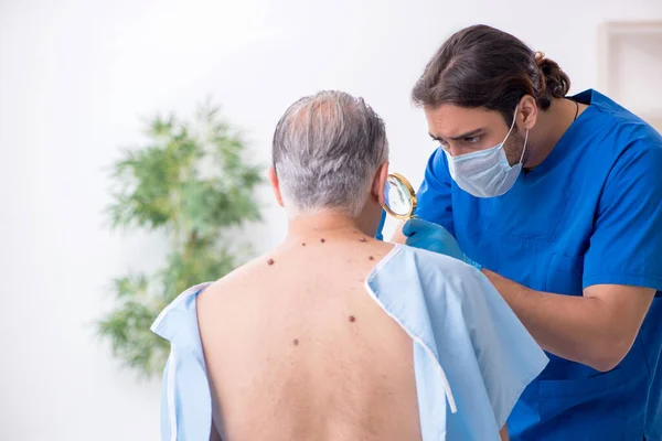 Viejo visitando joven médico dermatólogo — Foto de Stock