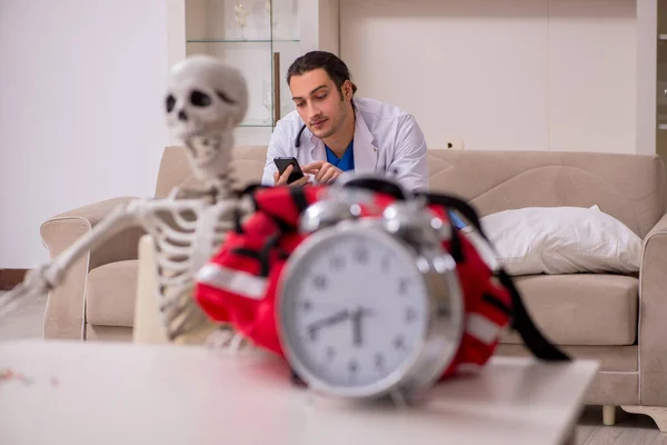 Jovem paramédico visitando paciente esqueleto — Fotografia de Stock