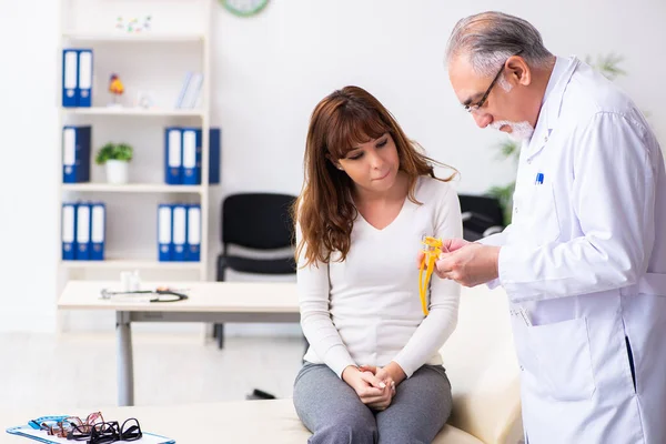 Jonge vrouw bezoekt oude mannelijke arts oogarts — Stockfoto