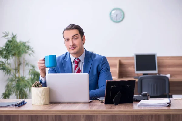 Young male employee drinking coffee during break — Stock Photo, Image