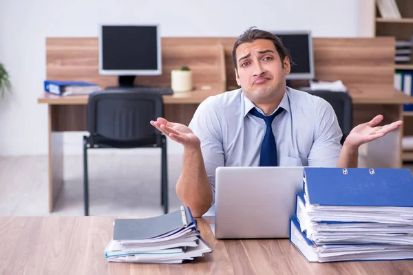 Young male employee unhappy with excessive work — Stock Photo, Image