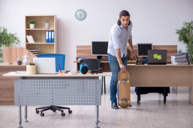 Ofiste kaykaylı genç bir erkek çalışan var.