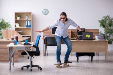 Ofiste kaykaylı genç bir erkek çalışan var.