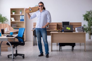 Ofiste kaykaylı genç bir erkek çalışan var.