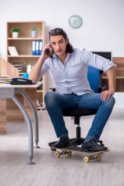 Ofiste kaykaylı genç bir erkek çalışan var.