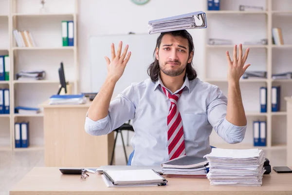 Joven empleado masculino infeliz con el trabajo excesivo — Foto de Stock