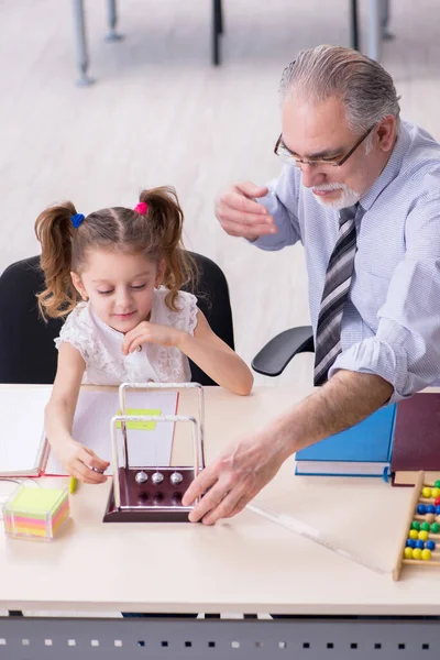 Oude leraar en schoolmeisje op school — Stockfoto