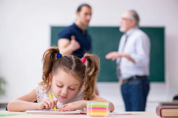 Jonge ouder, oude mannelijke leraar en klein meisje in de klas — Stockfoto