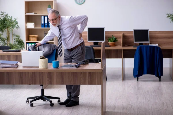 Velho trabalhador masculino que sofre de radiculite no local de trabalho — Fotografia de Stock