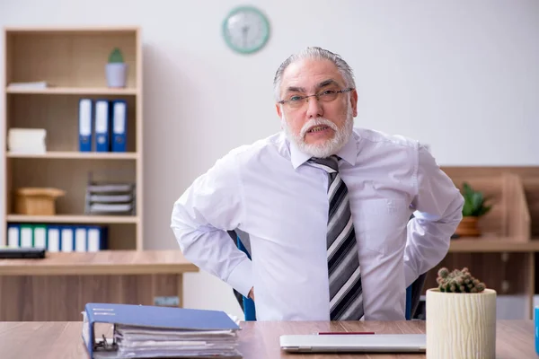 Alter männlicher Mitarbeiter leidet an Radikulitis am Arbeitsplatz — Stockfoto