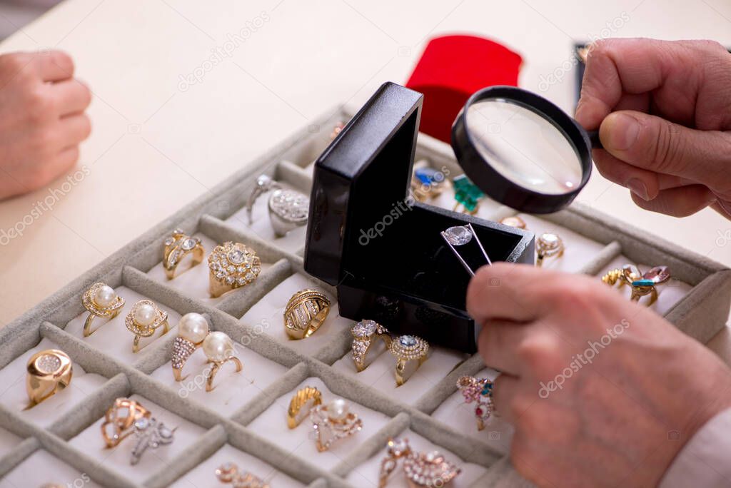 Young woman visiting old male jeweler