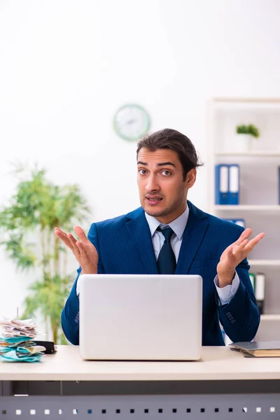 Joven empleado masculino infeliz con el trabajo excesivo — Foto de Stock