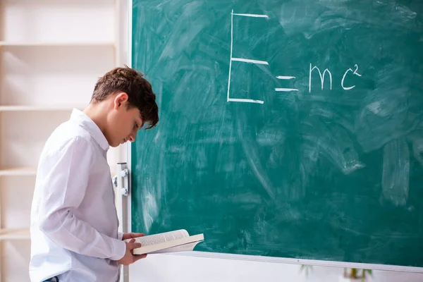 Skolpojke fysiker framför green board — Stockfoto