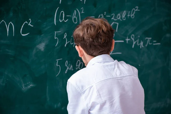 Schoolboy physicist in front of green board — Stock Photo, Image