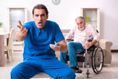 Tekerlekli sandalyedeki yaşlı adam ve genç kötü bakıcı.