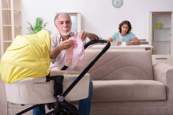 Pensionerad farfar som tar hand om nyfödda hemma — Stockfoto