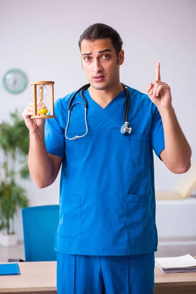 Fiatal férfi orvos az időgazdálkodás koncepciójában — Stock Fotó