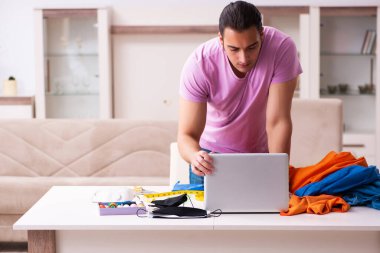 Genç erkek terzi salgın sırasında internet üzerinden sipariş alıyor