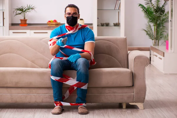 Jovem assistindo tv em casa em conceito pandêmico — Fotografia de Stock