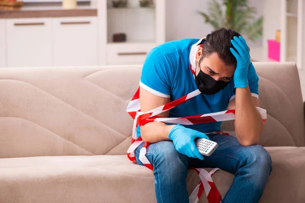 Young man watching tv at home in pandemic concept — Stock Photo, Image