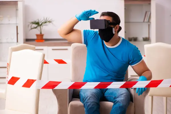 Fiatal férfi élvezi virtuális szemüveg otthon világjárvány idején — Stock Fotó