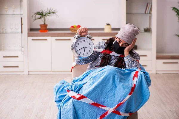 Young man suffering at home from coronavirus in time management — Stock Photo, Image