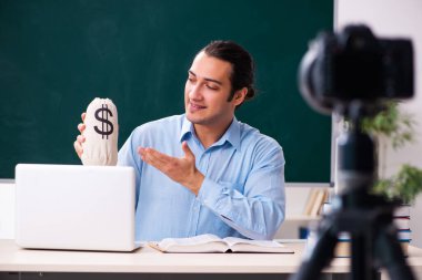 Genç yakışıklı öğretmen blogu için video kaydı yapıyor.