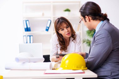 Genç işadamı ve bayan mimar yeni projeyi tartışıyor