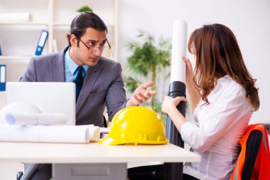 Genç işadamı ve bayan mimar yeni projeyi tartışıyor