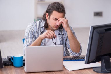 Ofiste çalışan genç bir erkek.