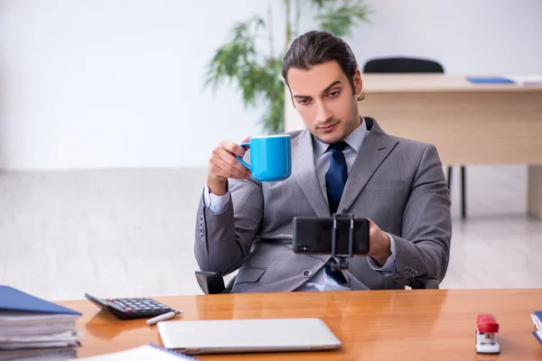 Joven empleado masculino con vídeo de grabación de teléfonos inteligentes para su blog — Foto de Stock