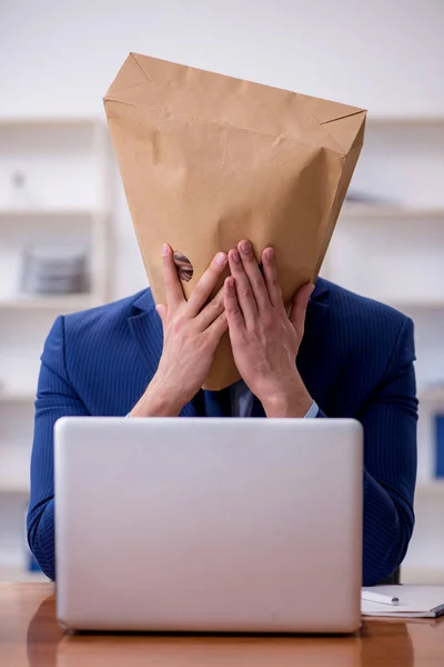 Joven empleado masculino con caja en lugar de su cabeza — Foto de Stock