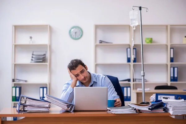 Giovane dipendente maschile che soffre sul posto di lavoro — Foto Stock