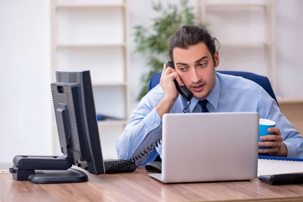 Giovane dipendente maschio che beve caffè in ufficio — Foto Stock