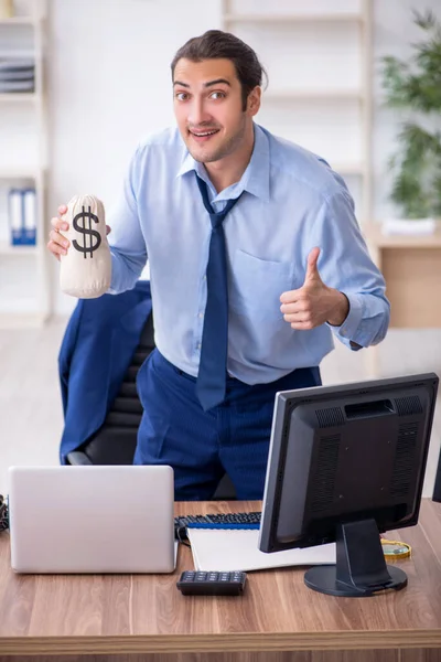 Giovane dipendente di sesso maschile che tiene denaro in ufficio — Foto Stock