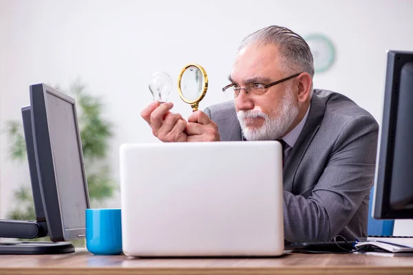 Viejo jefe sentado en el escritorio en la oficina — Foto de Stock