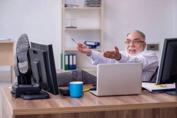 Velho chefe masculino sentado na área de trabalho no escritório — Fotografia de Stock