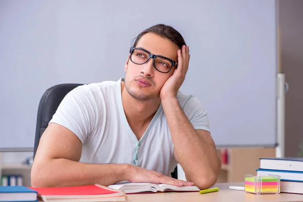 Junge männliche Lehramtsstudentin sitzt im Klassenzimmer — Stockfoto