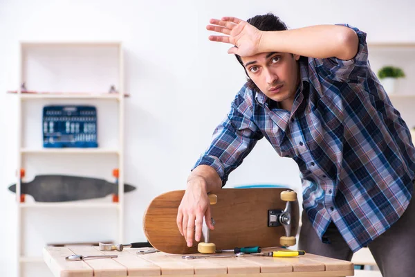 Joven reparando monopatín en taller — Foto de Stock