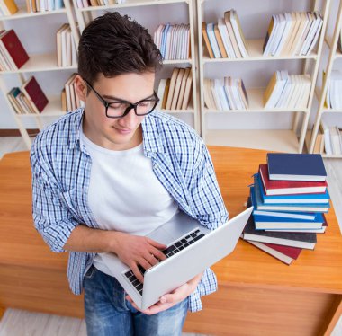 Kitapları olan genç bir öğrenci sınavlara hazırlanıyor.