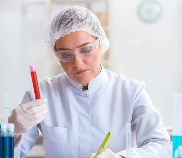 Женщина-врач проверяет образцы крови в лаборатории — стоковое фото