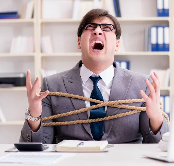 Businessman tied up with rope in office — Stock Photo, Image